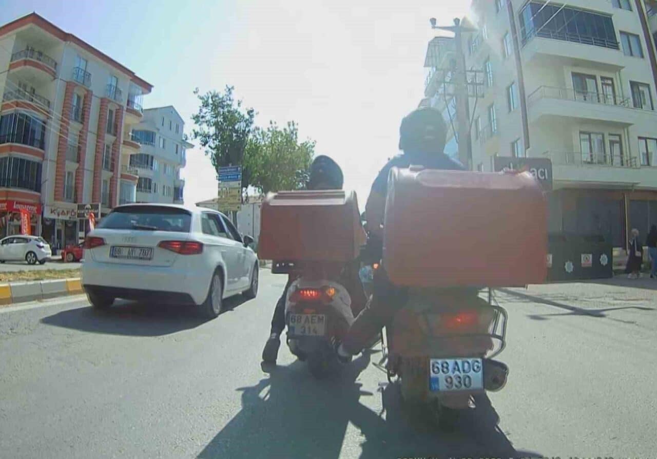 Aksaray'da arızalanan motosikletini arkadaşının itmesiyle trafikte sürdüren iki kurye, tehlikeli