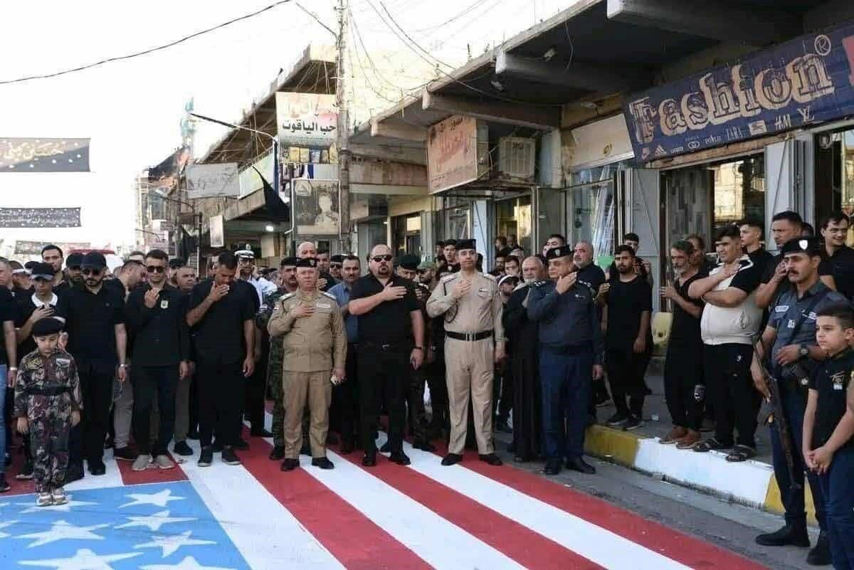 Irak İçişleri Bakanı Abdülemir el-Şemmari, Tuzhurmatu'da ABD bayrağı üzerinde yürüyen