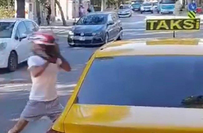 İzmir'in Bornova ilçesinde motosikletli bir genç, taksi sürücüsüyle yol verme