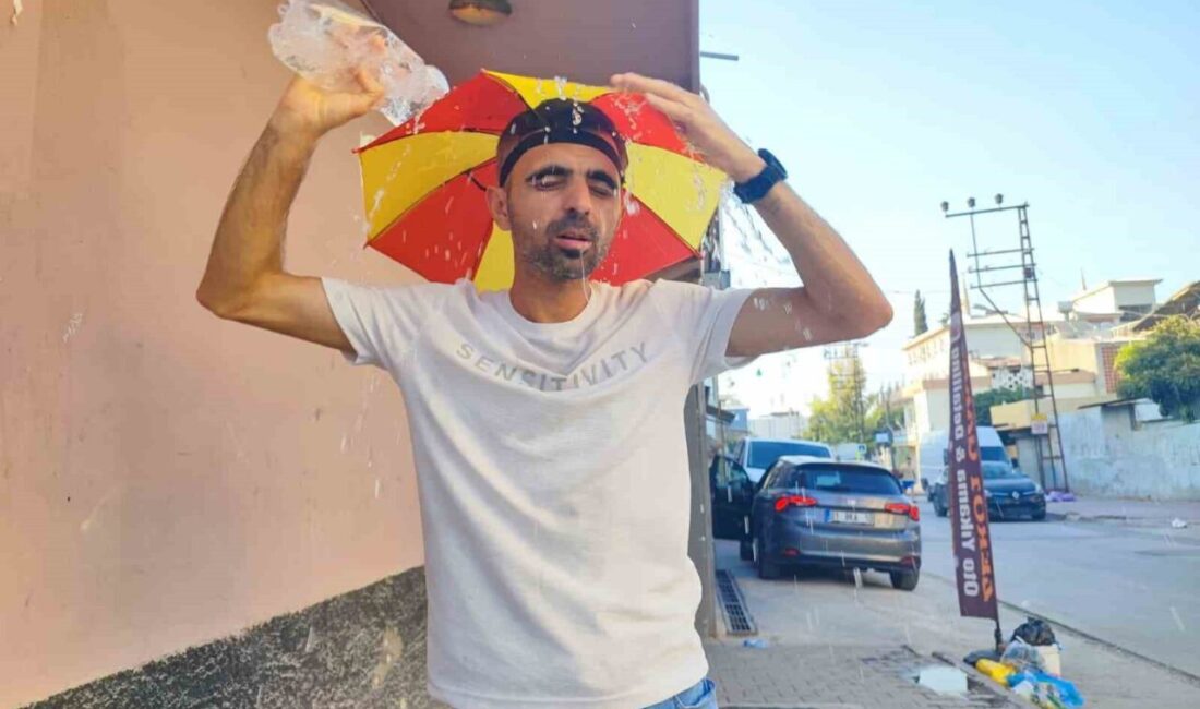 Adana'da sıcaklık 58 dereceyi aşınca, Mesut Akpınar kafasına şemsiye takarak