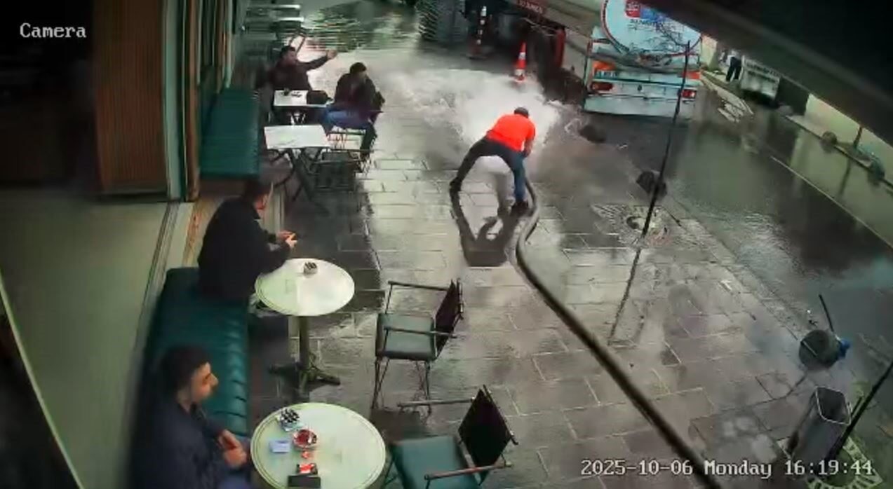 İstanbul Bayrampaşa'da bir kafe işletmecisi, iş yerinin önünü tazyikli su