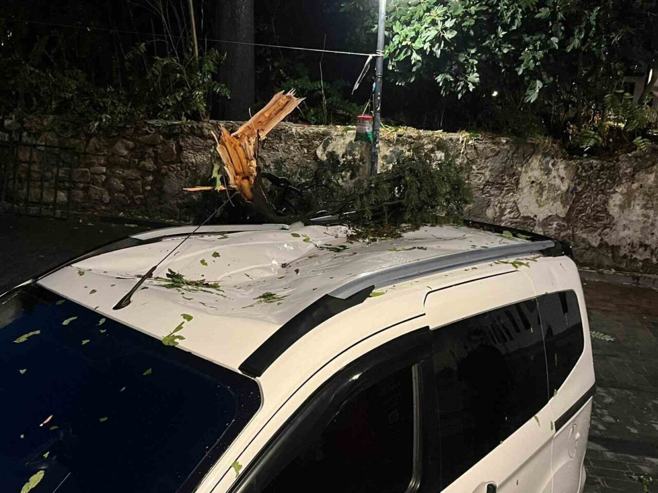 Antalya’da fırtına nedeniyle devrilen ağaç, park halindeki araca hasar verdi.