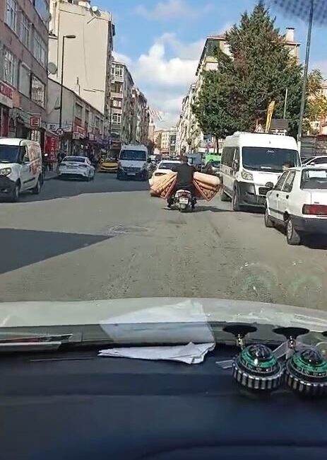 Bahçelievler'de motosikletle halı taşıyan bir sürücü, hem kendi hem de