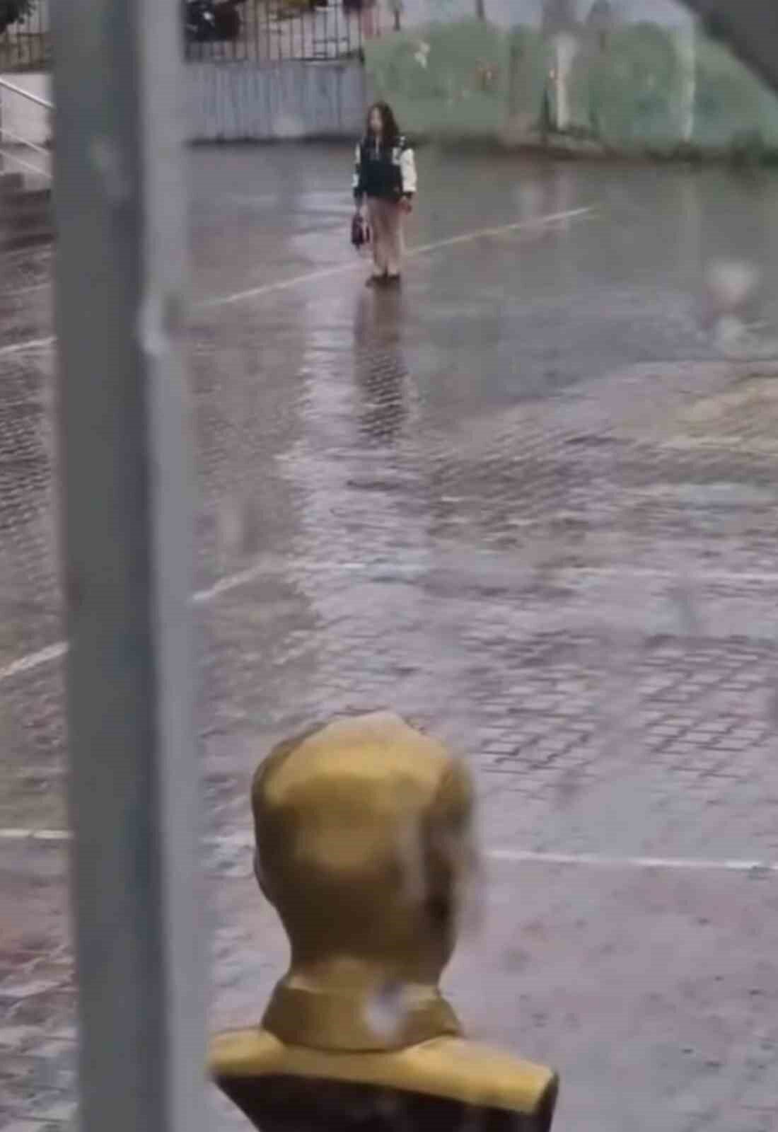 Iğdır'daki İnönü İlkokulu'nda yağmur altında İstiklal Marşı okuyan bir kız