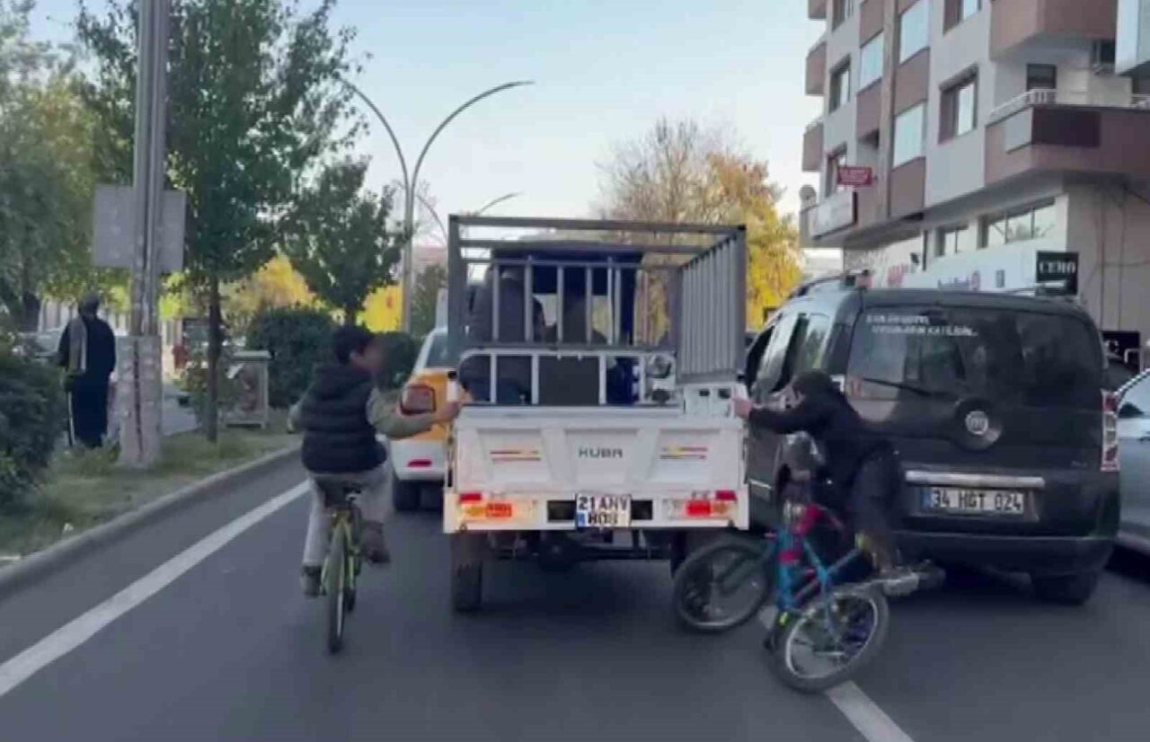 Diyarbakır'ın Yenişehir ilçesinde iki çocuk, sepetli bir motosiklete tutunarak tehlikeli