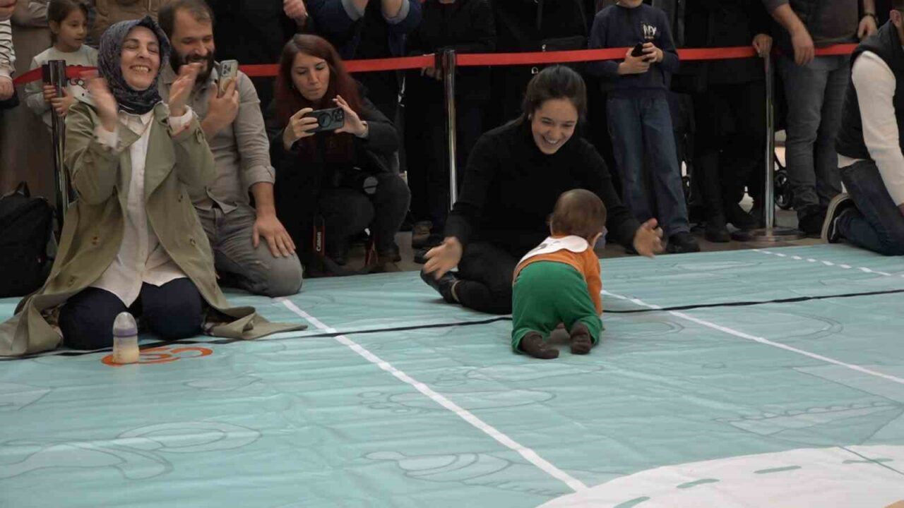 Rize'deki alışveriş merkezinde düzenlenen bebek emekleme yarışmasında aileler, miniklerden daha