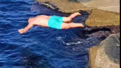 Zonguldak'ta soğuk havaya rağmen denize giren bir kişi, liman arkasında