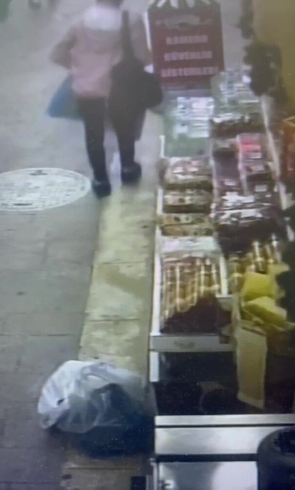 Zonguldak'ta bir kuruyemiş dükkanının önünde ceviz çalan bir kadın, güvenlik