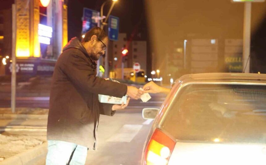 Aksaray’da ışıklı kavşaklarda mendil satışı yapan 42 yaşındaki adam, gece boyunca gelir elde etmeye çalışıyor.