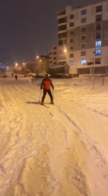 Elazığ’da bir kişi, kar yağışının ardından kayak takımıyla caddede kaydı.